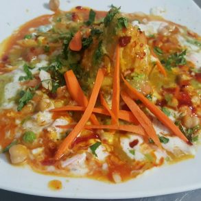 A plate of food with carrots, broccoli, and other assorted vegetables.